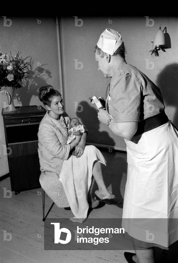 Midwife May Guthrie-Lacy photographs the 287th baby which she has delivered at Lytham Hospital. 
Two day old Nicola Manton and her mother 23 year old Christine will join all the others happy snaps in May Lacy's albums. 
December 1969