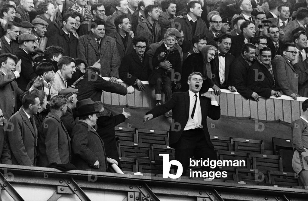 English League Division One match at Goodison Park. Everton 4 v Fulham 1. The win gave Everton the title on the last day of the season. Injured Everton player Gordon West celebrates like a fan as Everton clinch the title. 6th April 1963 (photo)