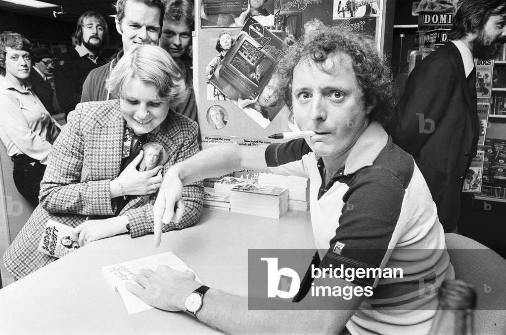Jasper Carrott, comedian, actor, television presenter and personality, pictured signing copies of his new book and record and WH Smith, Birmingham, 20th October 1979 (b/w photo)