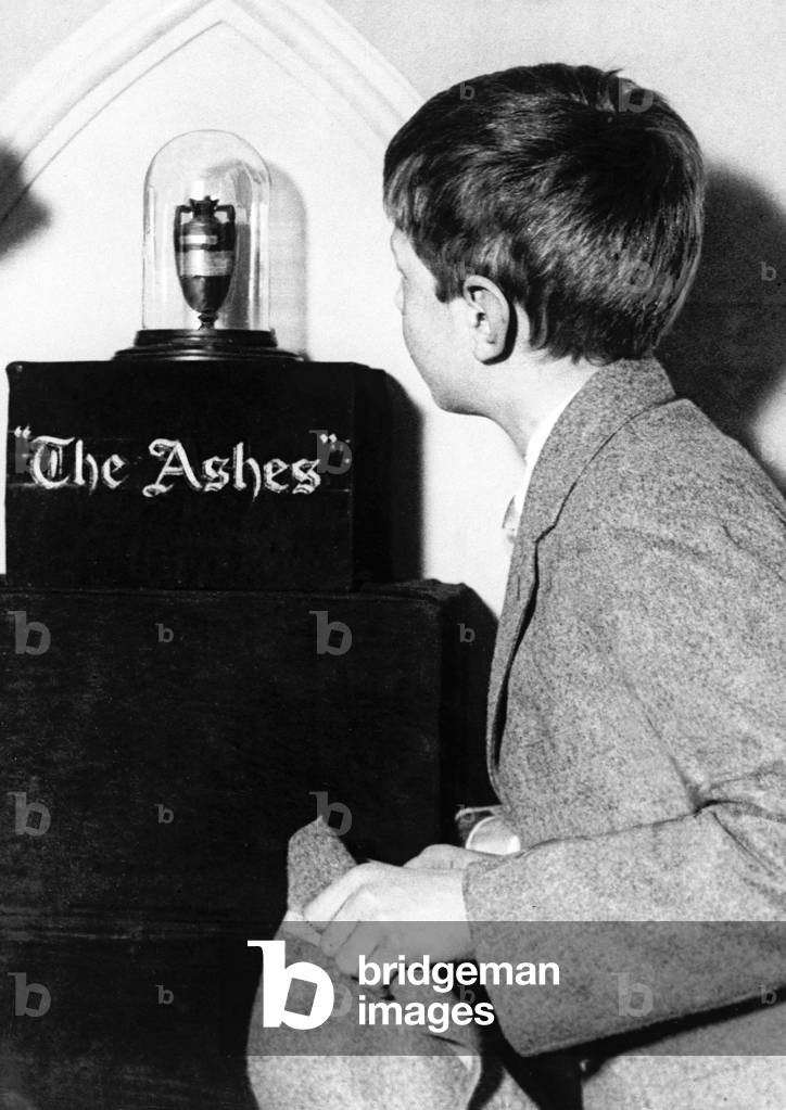 The Ashes Trophy, a young schoolboy looks on (b/w photo)