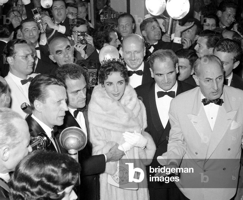 Elizabeth Taylor and husband Mike Todd surrounded by photographers in the theatre before showing of his film 