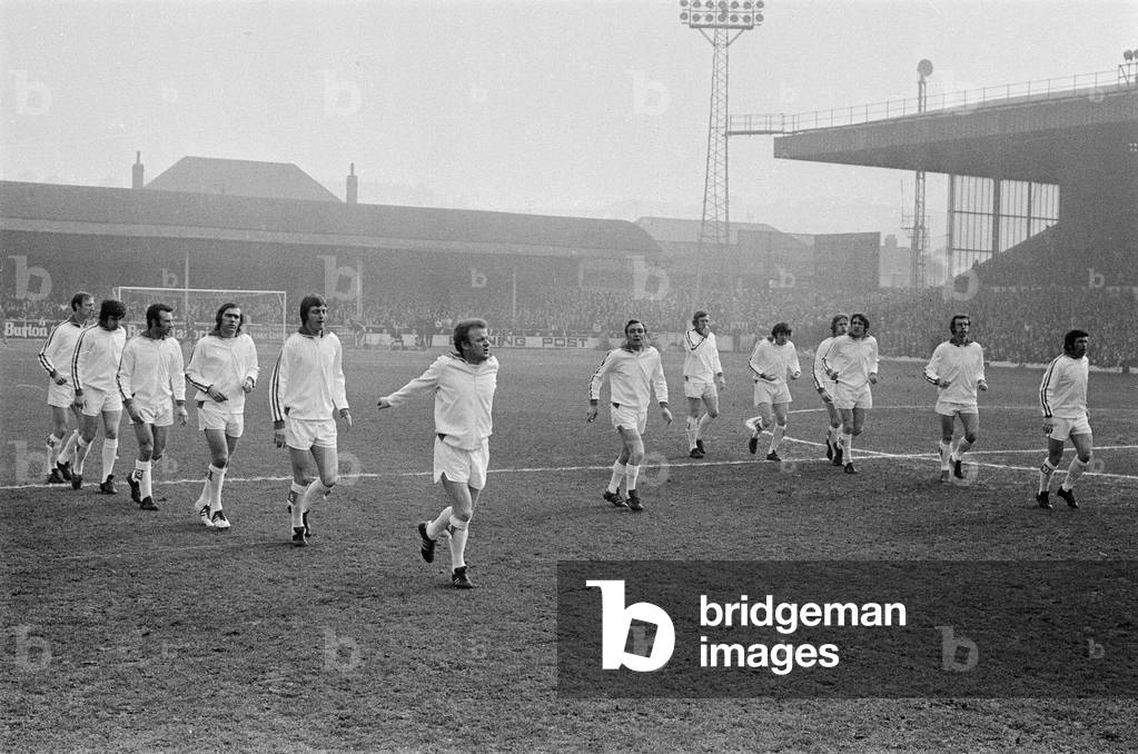 FA Cup Quarter Final match at Elland Road. Leeds United 2 v Tottenham Hotspur 1 The Leeds team led by their manager Les Cocker and captain Billy Bremner warm up on the pitch before kick off, 18th March 1972 (b/w photo)