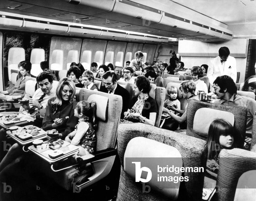 Passengers relax in the spacious interior of a Boeing 747 'Jumbo Jet' airliner / aircraft, c. 1973 (b/w photo)