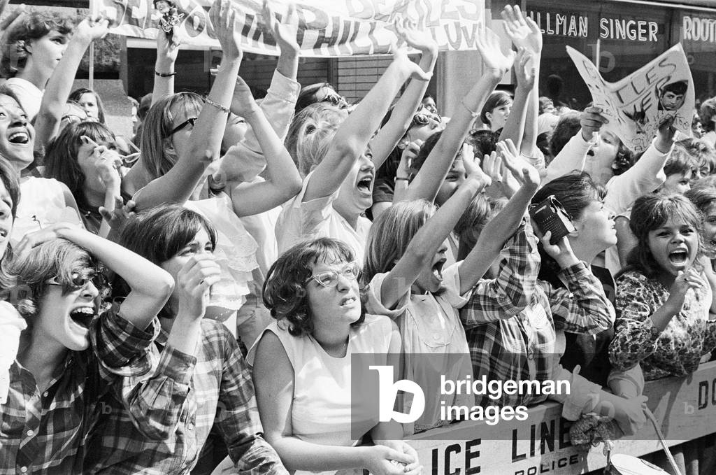 The Beatles in New York City, on their North American Tour ahead of their concert to be held at Forest Hills. Cheering fans gathered outside the Delmonico Hotel in New York where the band are staying. 28th August 1964 (b/w photo)