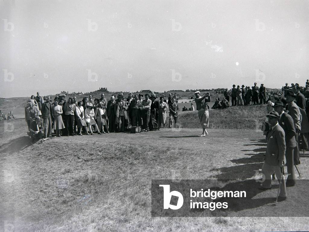 Spectators watch a competitor tee off during the 1949 British Open at Royal St George's Golf Club, 8th July 1949 (b/w photo)