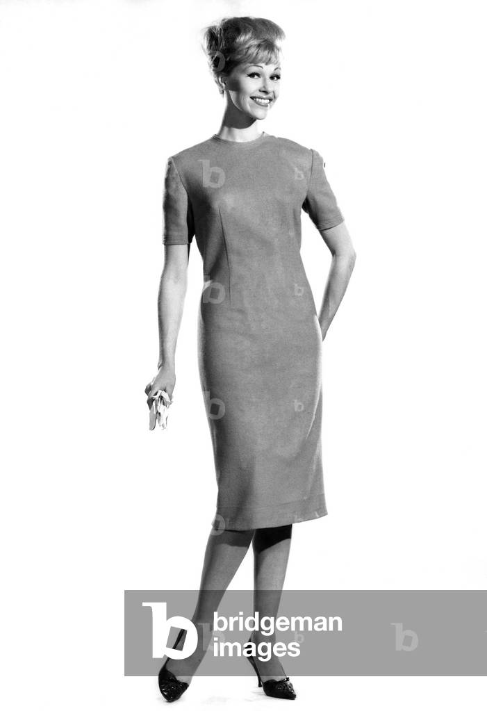 Woman wearing long, straight dress. Reveille Fashions. Jo Wanning. October 1962