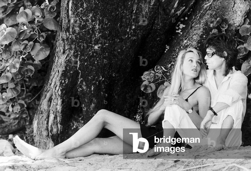 Rolling Stones: Jerry Hall and Mick Jagger sit on a Barbados beach February 1987
