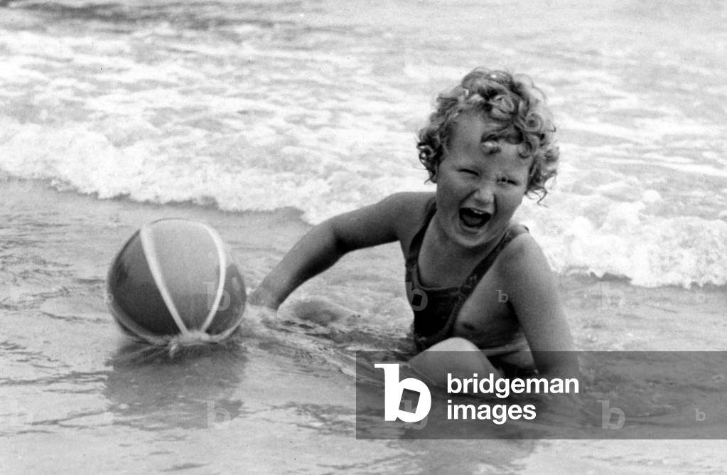 Yound girl playing with her beach ball during a holiday at the seaside
Circa 1945