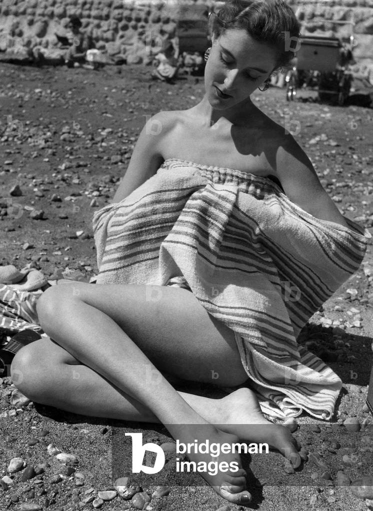 Undressing on the beach with aid of a towel has been made easy by simple device. May 1952 (photo)