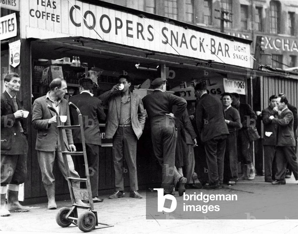 A cup of tea makes a welcome break for these men, many of whom have been working in and around Cardiff's Custom House Street, unloading produce since first light, 12th May 1960 (b/w photo)