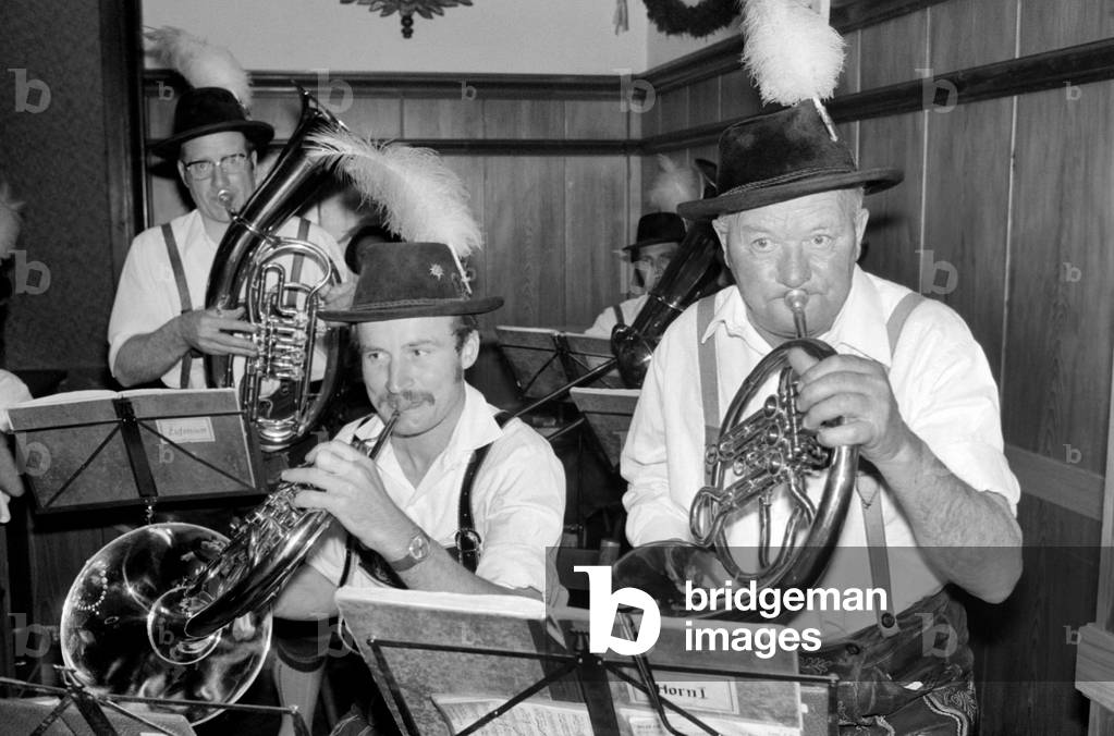Members of a Bavarian band performing on stage wearing traditional Bavarian dress during a night out in Ruhpolding near Munich, May 1975 (b/w photo)