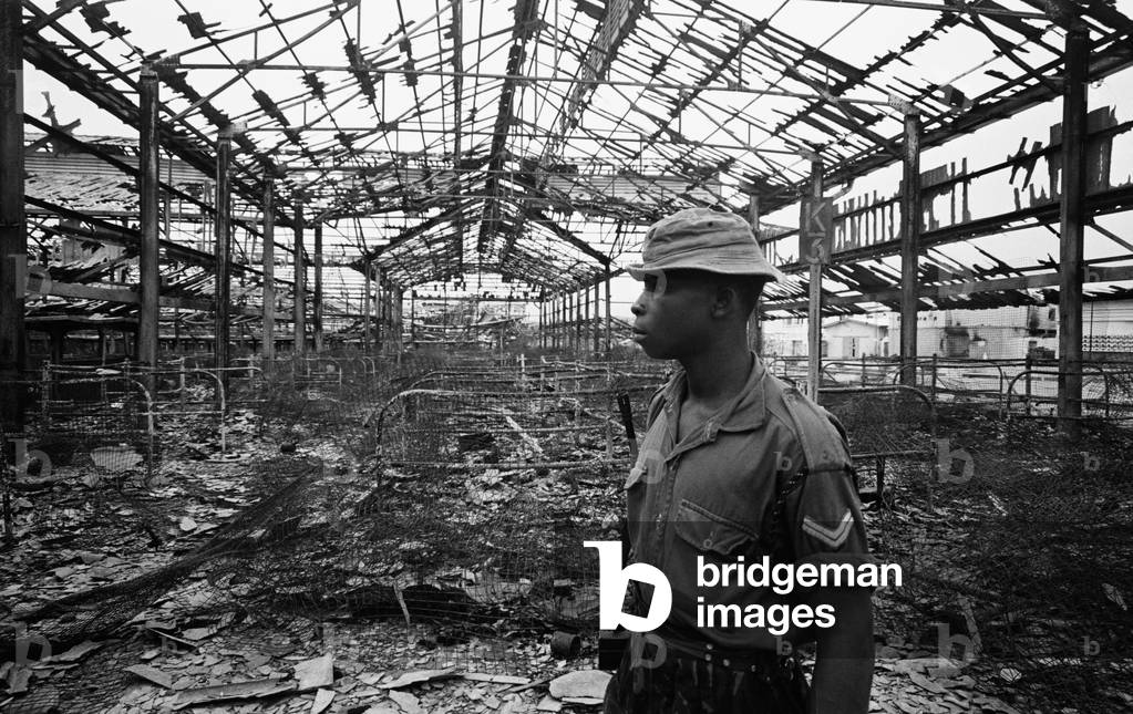 Pictures taken during the Daily Mirror's attempt to reach the refugee camps of Onitsha and Asaba during the Biafra conflict. Picture shows a soldier inspecting the ruins of Onitsha market place after it was blown and gutted during fighting for the town.16th July 1968.