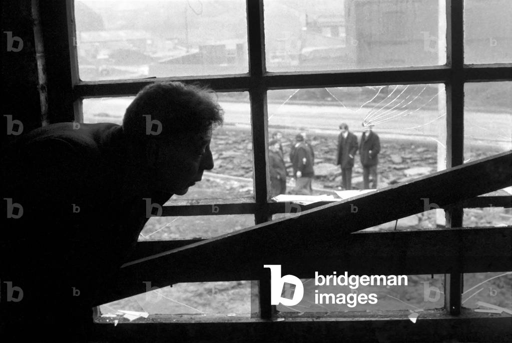 Cyril Eachus waits for the bailiffs to arrive to evict him from his old works, seen here he looks out of the window as waiting demolition man wait for the move in. December 1969