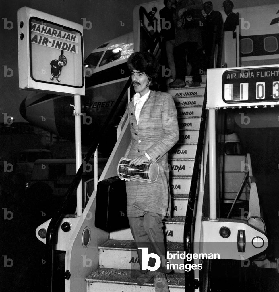 George Harrison of The Beatles at Heathrow airport where he arrived from India where he has been learning and recording Indian music, January 1968 (b/w photo)