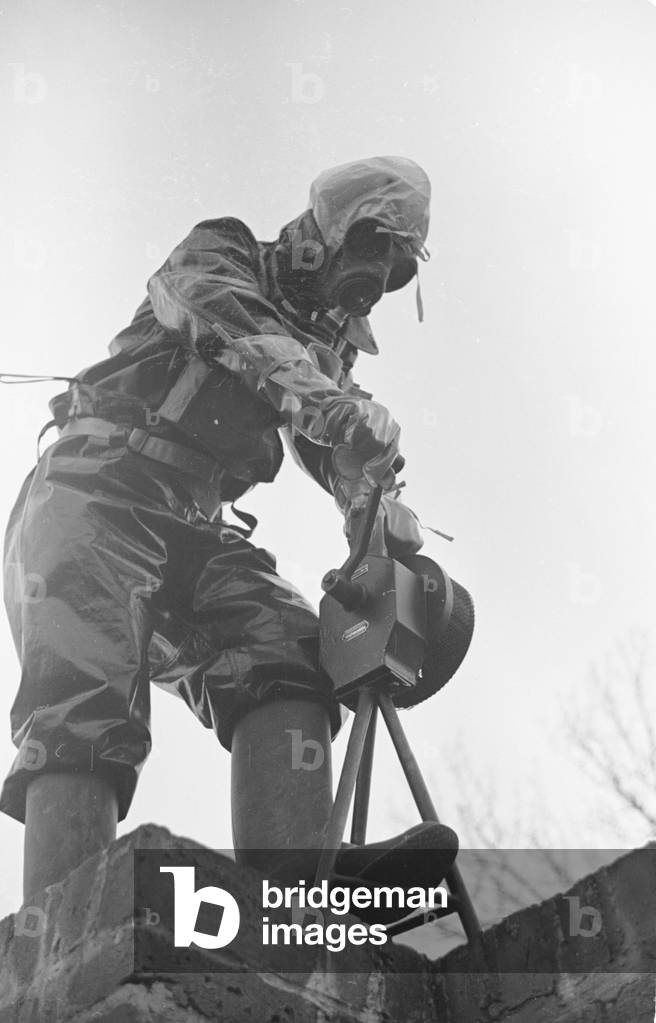 Preparations for war. ARP warden gets use to his gas mask and coat during a civil defence gas attack exercise in Kingston. June 1938 This clothing would evolved into the NBC suits used the British Army today, 01/06/1938