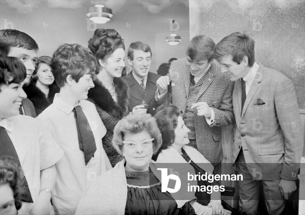 A large crowd of housewives and children gathered outside the Standard Cinema Buildings in Tile Hill Lane, Coventry, today, to catch a glimpse of the Bachelors who were opening a new ladies' hair stylist salon. The salon called Eileen's is the first shop to be opened in the development, which has involved rebuilding the cinema. The three Bachelors arrived late after a breakdown on their journey from Birmingham, to be greeted by Mrs. Eileen Kelly, who is starting the salon with her husband. The trio cut a pink tape and unlocked the door after a stormy passage through the crowd of autograph hunters. The salon is equipped with the latest push-button driers and can accommodate about 12 customers at one time. 6th February 1967 (b/w photo)