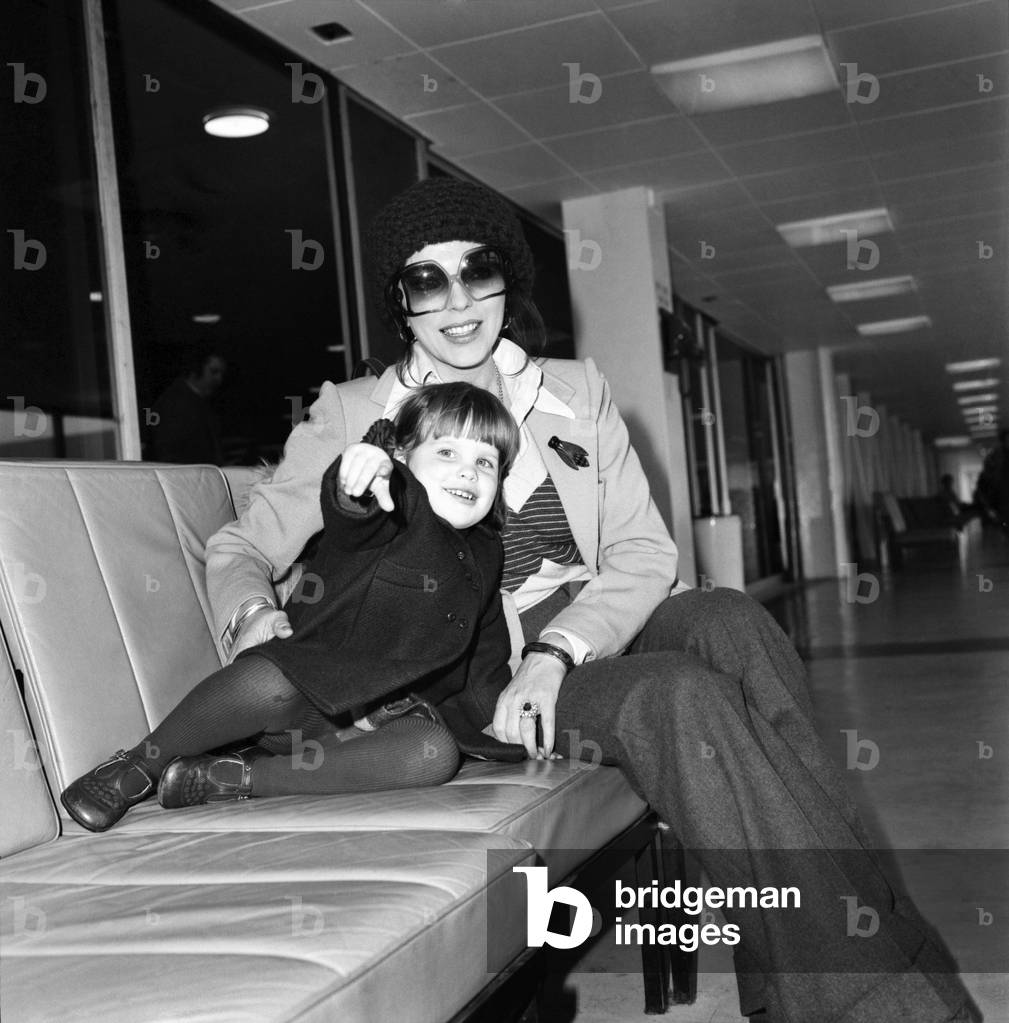 Actress Joan Collins and her 2 year old daughter Katyania leaving Heathrow airport for New York, 23rd February 1975 (b/w photo)