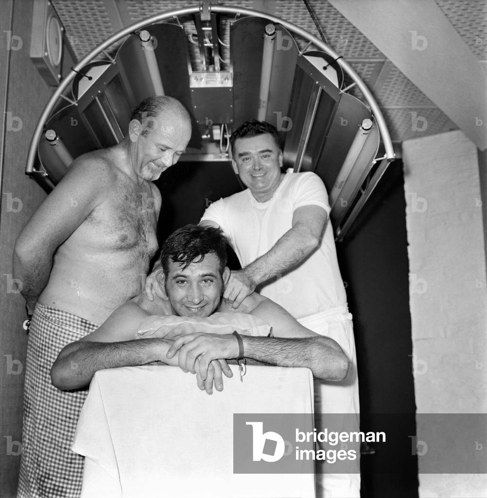 Sport: Rugby Union South African visit to Sauna baths: Sprinfbok manager Corrie Bornman looks on as Gawie Carelse receives massage from masseur Frank Mathews at a Sauna in Funnell Street, Manchester. December 1969