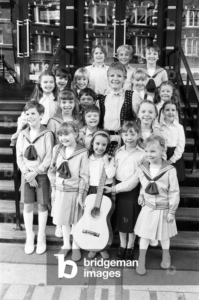 Petula Clark with the final selection of 18 children, three groups of six, children in costume who will be in 'The Sound of Music' at the Apollo Theatre in Victoria, London. 26th March 1981 (b/w photo)