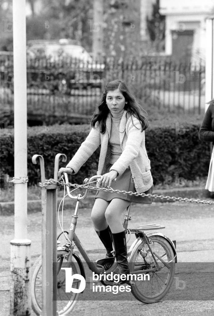 A girl riding her bike in a street in a French town, April 1975 (b/w photo)