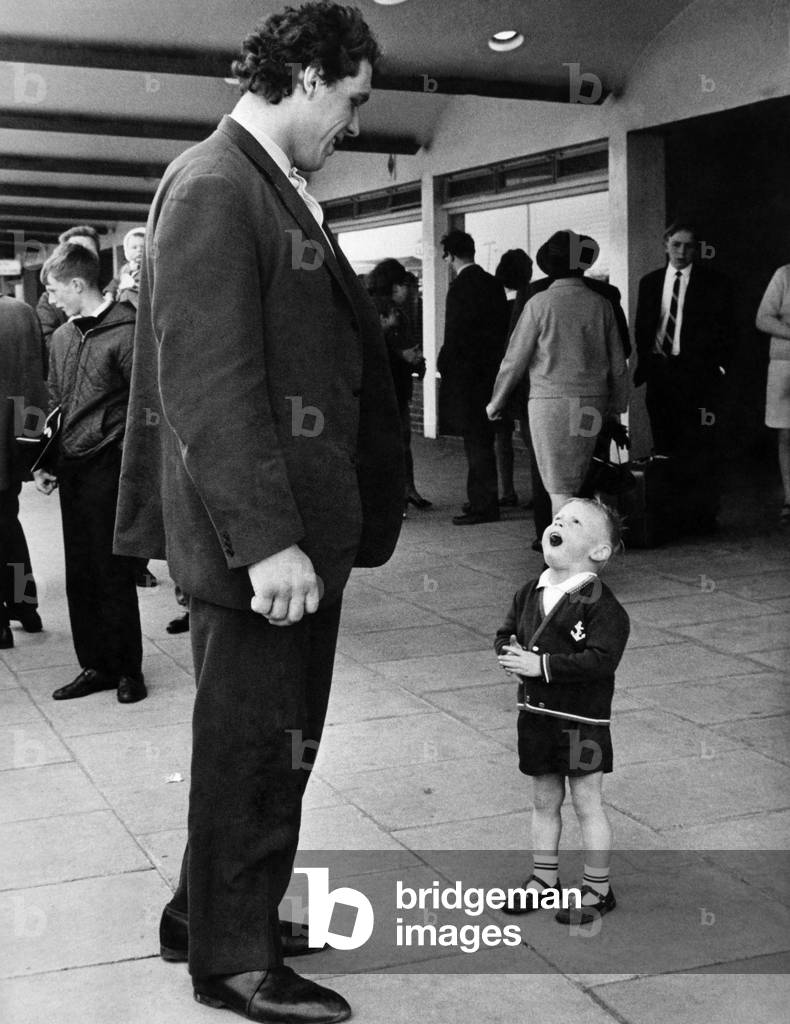 David meets Goliath - 2 years-old, David Edwards, of Park Street, Heaton Park, Manchester looks up in amazement at Jean Ferre, the European wrestling champion, a 23 year-old, 6ft 11ins, Frenchman, who arrived at Manchester Airport today (Sunday). June 1969