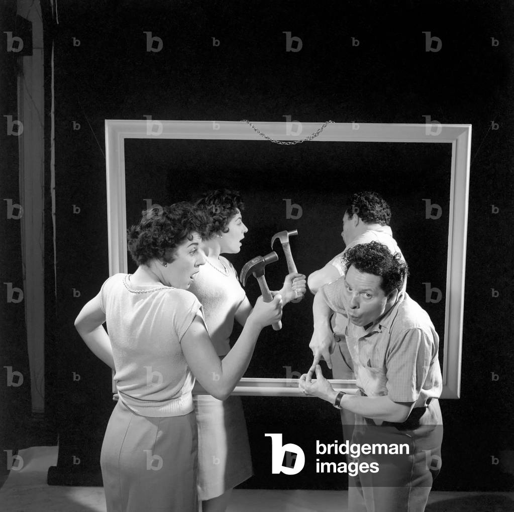Mirror image: A couple argue in front of a mirror, 1958 (b/w photo)