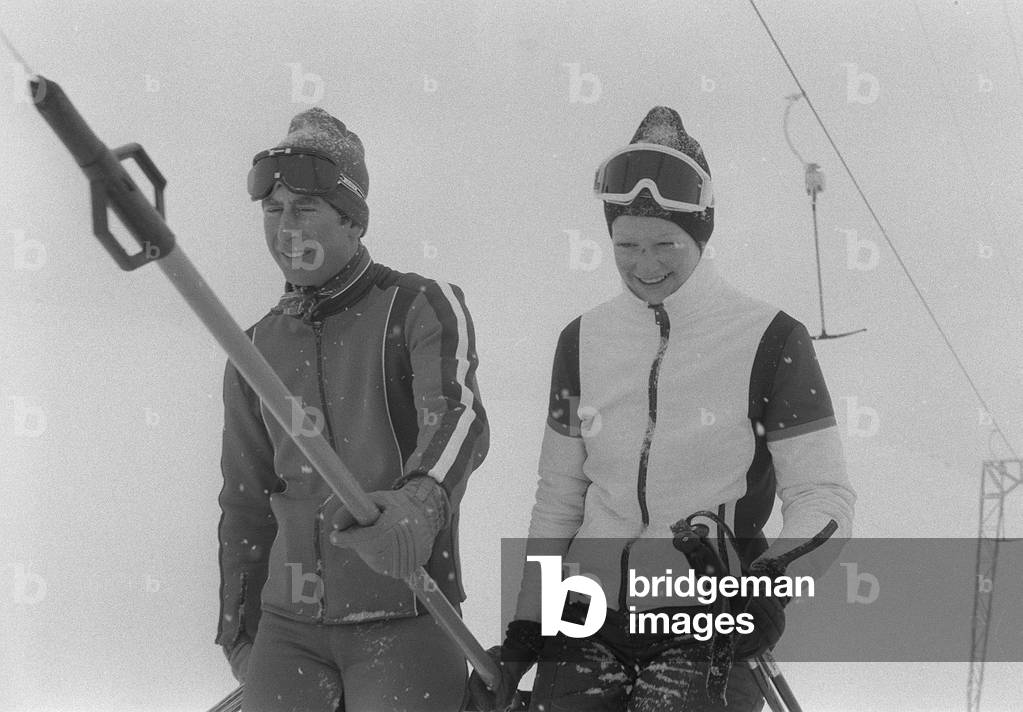 Prince Charles with Lady Sarah Spencer sharing a ski lift chair in Switzerland Wearing goggles and ski suit in 1970s (b/w photo)