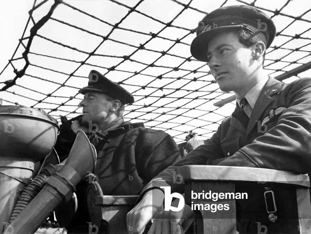 A Commander and Pilot Officer on bridge of a destroyer. The RAF is sending their crews out with convoys to gain practical experience and so put it to use when they are out on fighter Escort Patrol. August 1941 (b/w photo)