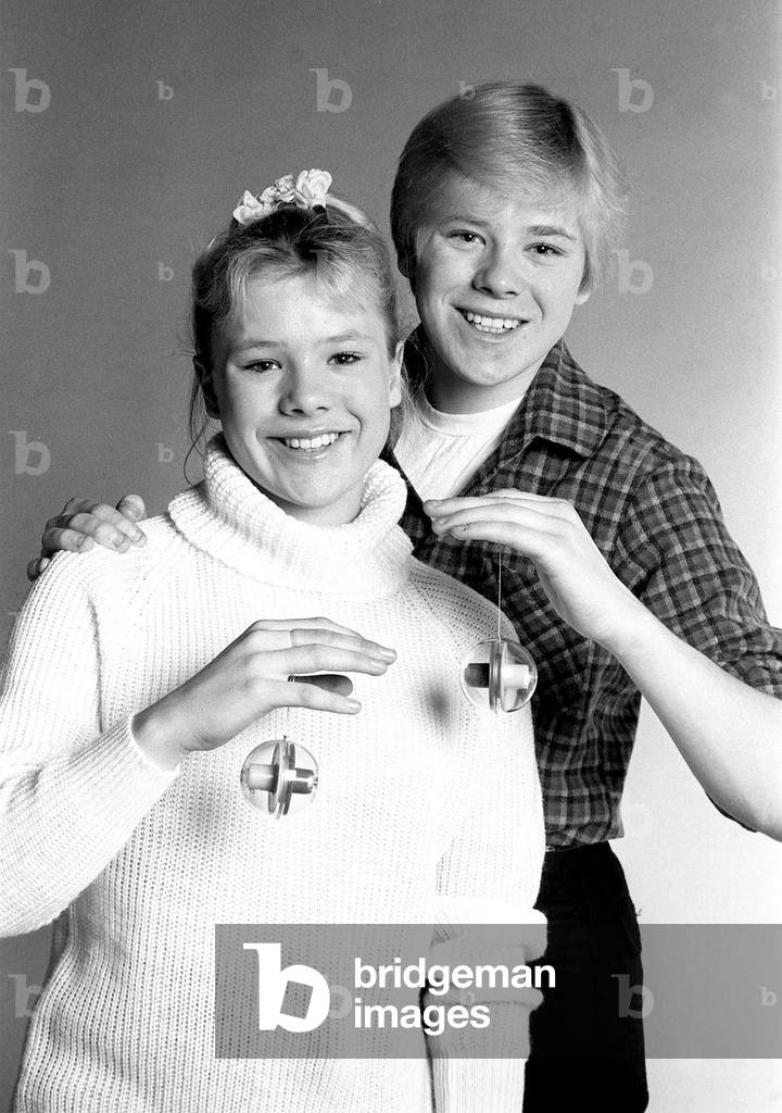 Actress Letitia Dean with brother Stephen try out new yo yos. January 1981 (b/w photo)