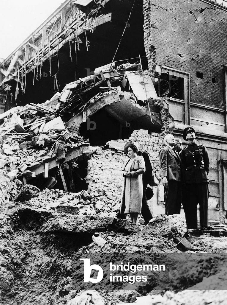 Queen Elizabeth and King George VI tour bomb sites during the Blitz of London Original Caption: The King and Queen visited, again, the bombed areas of London yesterday. They saw little homes blasted out of occupation. And once, while the King was being told how damage had been caused, the Queen wandered a few steps alone . . .to a spot where another woman and mother once had a home. . . .And there she stood, silent and sad 19th September 1940 (b/w photo)