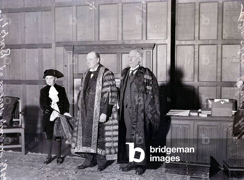 Mr Winston Churchill made Chancellor of Bristol University 1929 with Professor Loveday and a boy holding the coat tails of his embroidered robes, December 1929 (b/w photo)