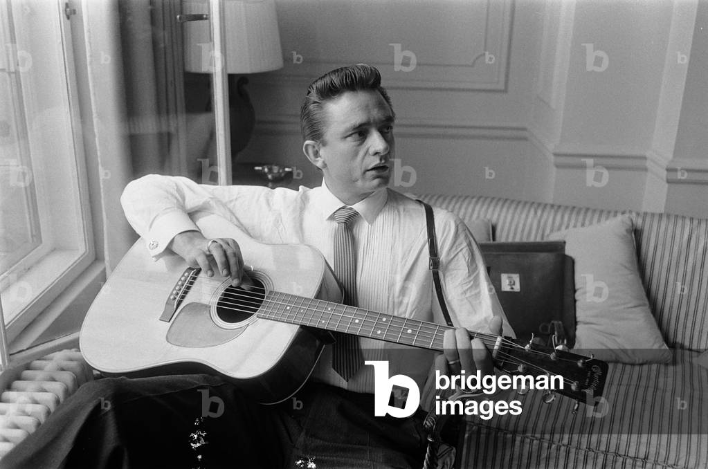 American country singer and musician Johnny Cash poses for photographers at the Savoy Hotel in London. 17th September 1959 (b/w photo)