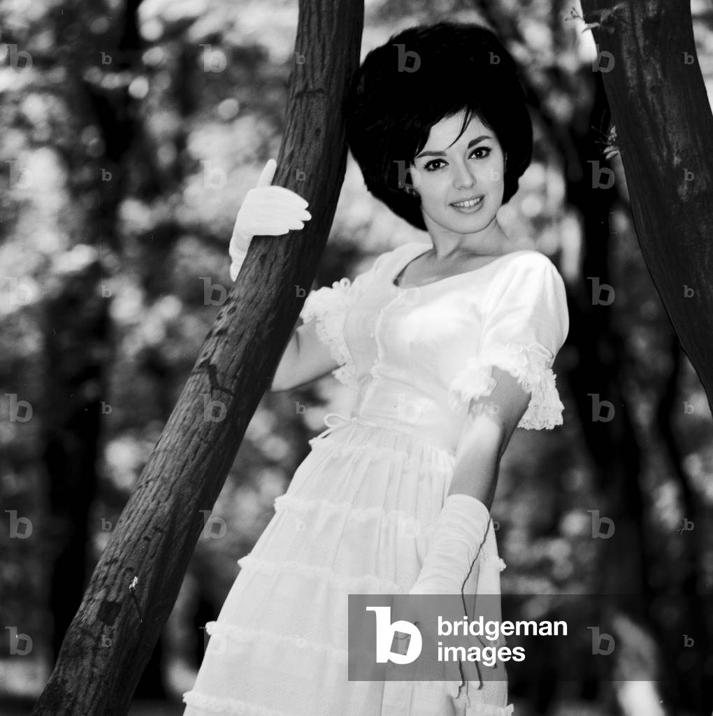 Actress and singer Susan Maughan, aged 20, photographed in a park near her home in Hornsey, London wearing an Ascot styled hat and dress. 11th June 1963 (b/w photo)