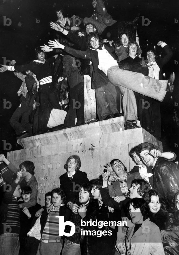 Part of the crowd of New Year revellers who besieged the statue of Lady Godiva in Broadgate, Coventry city centre. 1st January 1977 (b/w photo)