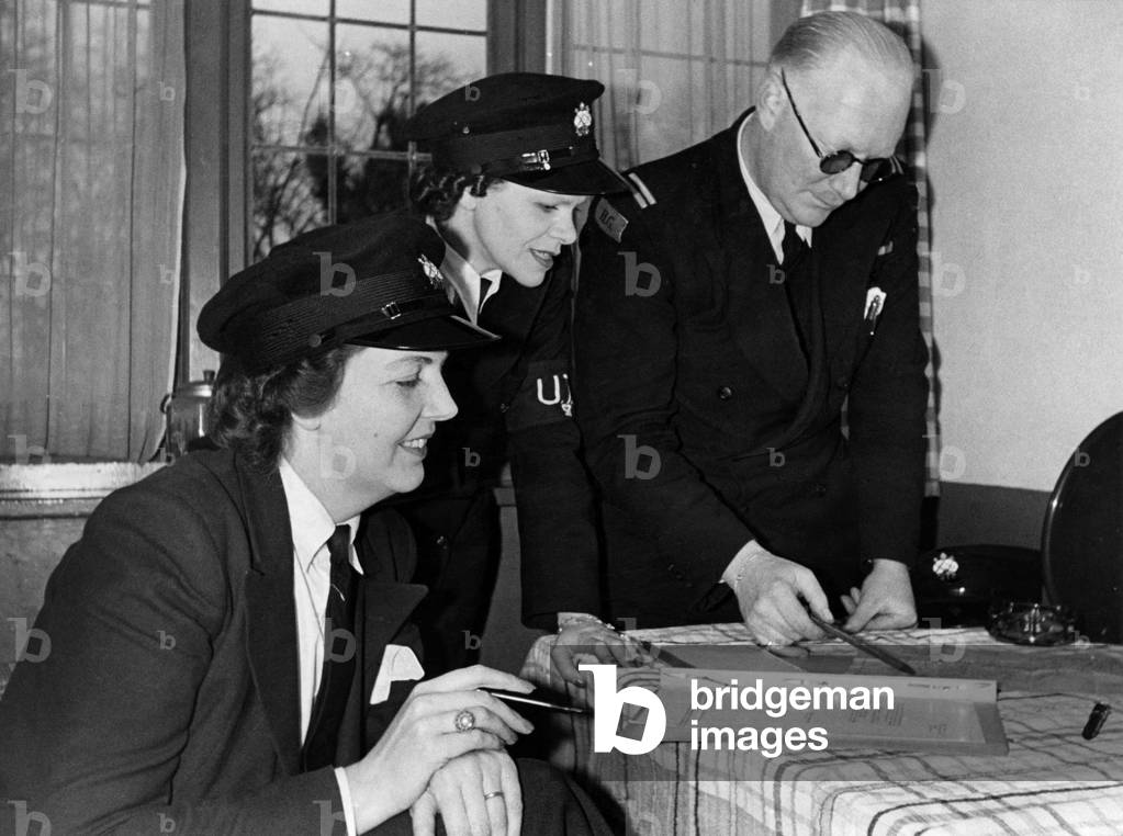 World War II Women. Mrs. W.C. Thiele (right) and Mrs. P. Bartlett who are the helmsmen of Patrol Launches of the Upper Thames Patrol (Home Guard). Pictures taken at Maidenhead where they have been on active service since the inception of the U.T.P. Lieutenant Thiele is seen giving instructions for there night patrol duty. January 1941