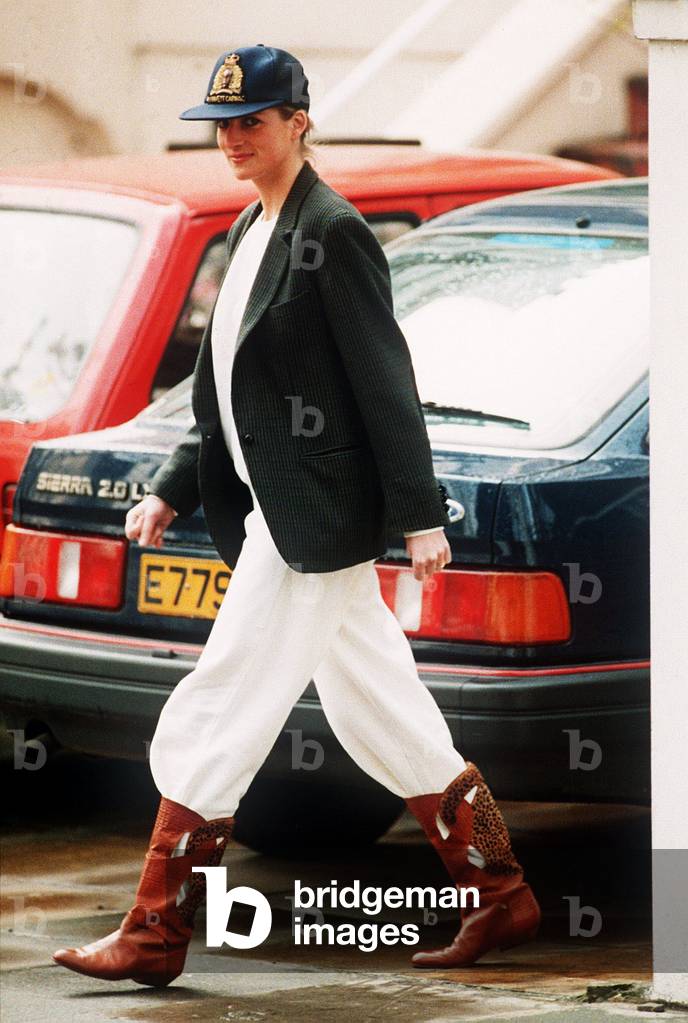 Princess Diana wearing an unusual combination of white trousers, boots, a blazer jacket and a baseball cap
April 1989
