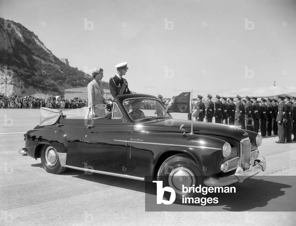 Queen Elizabeth II and the Duke of Edinburgh in an open car reviewing troops on a visit to Gibraltar, this was their last port of call of this Royal Tour. More than 2000 men were on parade. 10th May 1954.