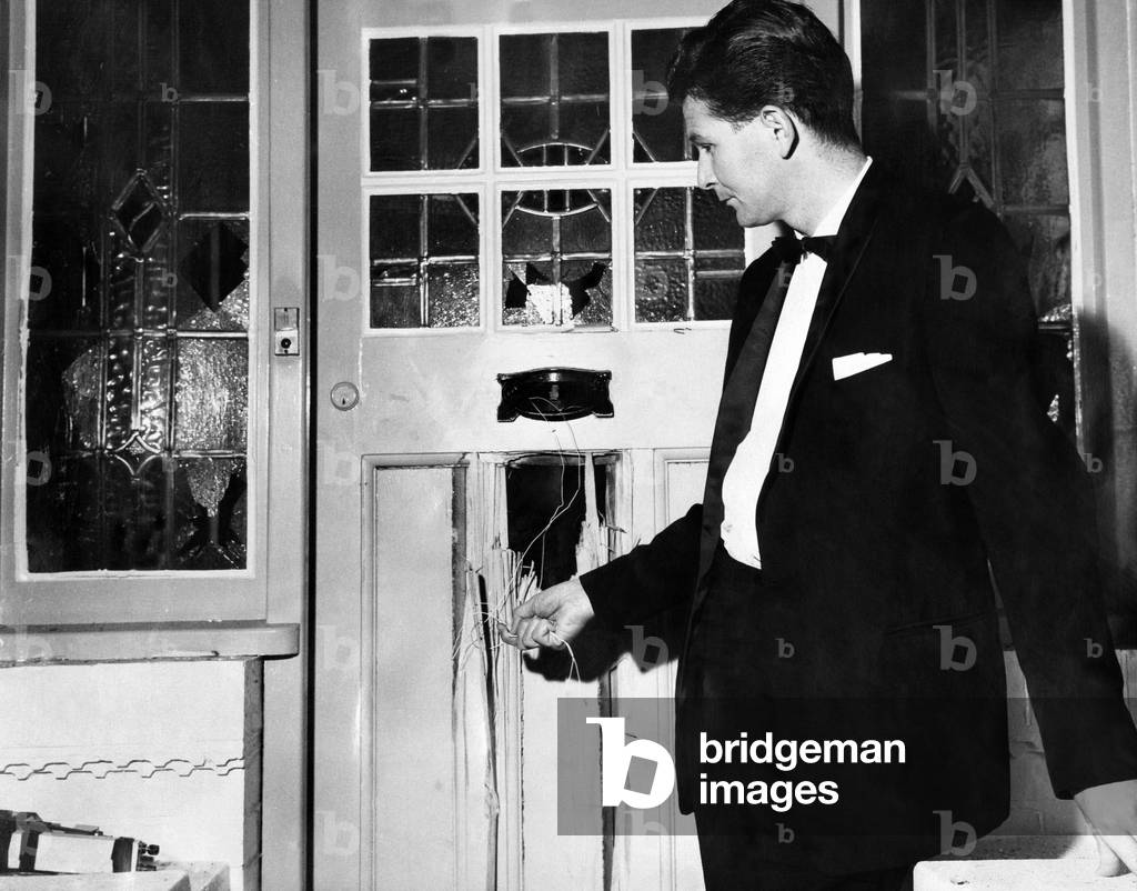 Peter Griffiths Conservative MP for Smethwick, holding wires which triggered off a bomb inside the front door of his home. 27th October 1965 (b/w photo)