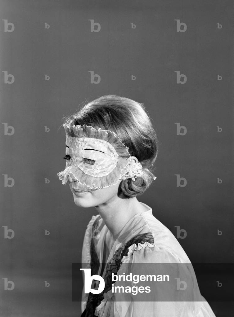 Model Dawn Chapman wearing face mask to aid her in getting a good nights sleep, 1962 (b/w photo)