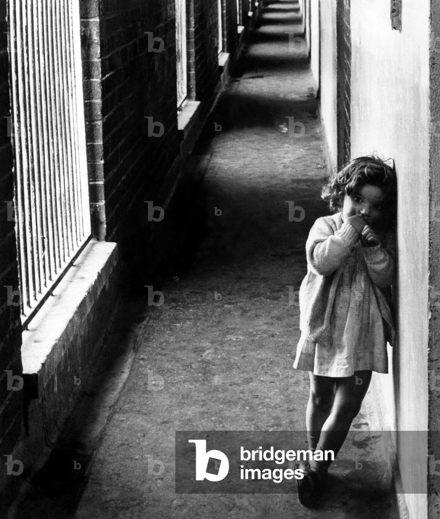 The Noble Street flats Housing Estate in Scotswood, Newcastle, which was built in the late in 1950s and demolished in the late 1970s after being blighted by social problems, vandalism, a high crime rate and was nicknamed Alcatraz by the local residents. A young girl looks sad in one of the prison-like corridors 7 December 1973 (b/w photo)