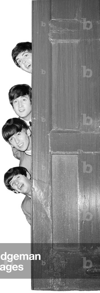 The Beatles pose backstage at The Palladium theatre behind a door, 1963 (b/w photo)