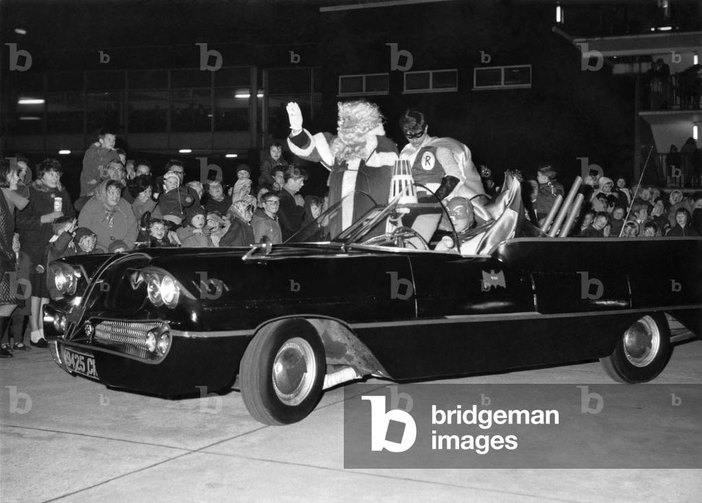 Batman and Robin escort Father Christmas safely into a city store as thousands of children surge around a gleaming Batmobile as it drove up to Lewis's in Market-Street, Manchester. They rushed towards the caped crusadere but the pair escaped into the store. Dressed up as Batman was 27-year-old building manager Frank Smith and Robin was publicity artist John Scholes. November 1966