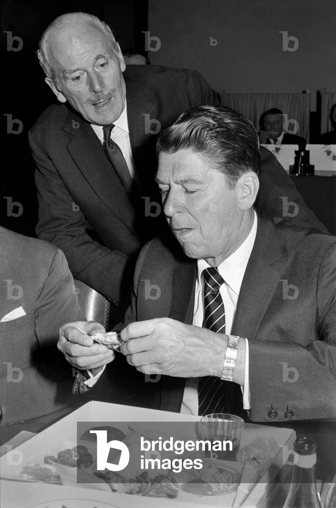 The Institute of Directors annual conference at the Albert Hall, more improperly known as 'The Picnic' from the practice of serving lunch in picnic boxes to the 3,000 odd, directors who attend, was addressed today by such diverse speakers as Barbara Castle, Ronald Reagan, Governor of California, Ian McLeod and John Betjeman. 
Governor Ronald Reagan rejects the knife and fork approach to his cold chicken. 
November 1969