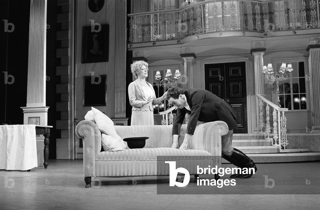 Actor Robert Lindsay in his role as Bill Snibson in the stage musical Me and My Girl at the Adelphi Theatre in London, performs a somersault over the sofa during the performance. February 1985 (b/w photo)