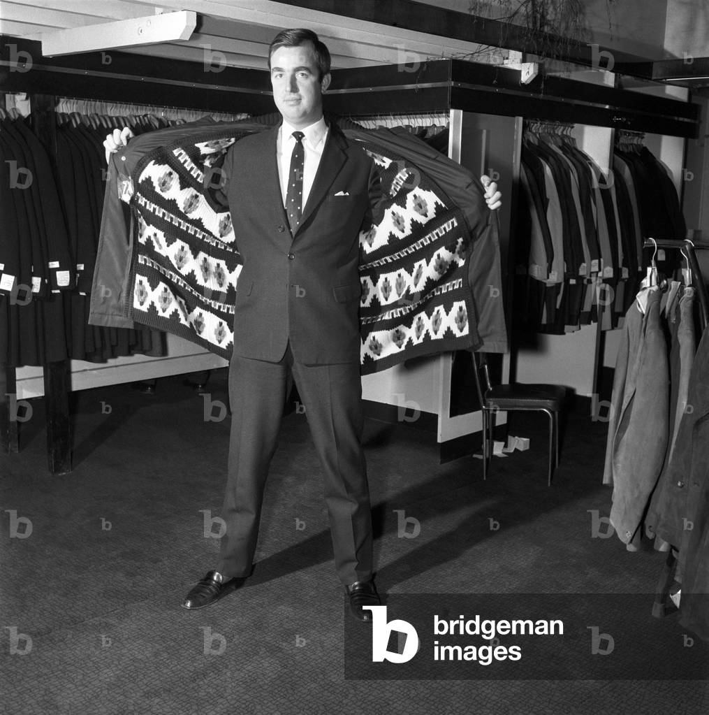 Male model wearing raincoat in menswear department, 1966 (b/w photo)