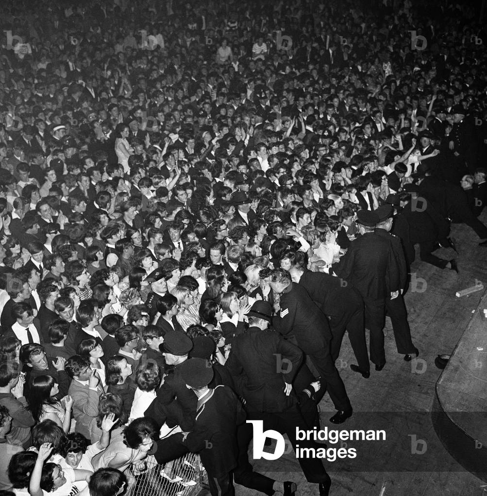 The Rolling Stones performing at the Palace Ballroom, Douglas, Isle of Man.
Police struggle to hold back fans at the front of the crowd.
13th August 1964.