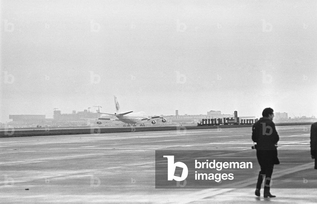 Photographer on the apron following the arrival of the first Boeing 747 'Jumbo Jet' at Heathrow Airport. The aircraft had been delayed for three hours in New York where one of the fan jet engines had been giving trouble and had to be replaced. The aircraft carried over 300 employees of the airline Pan-Am, on this proving flight before the plane enter normal service. 12th January 1970 (b/w photo)