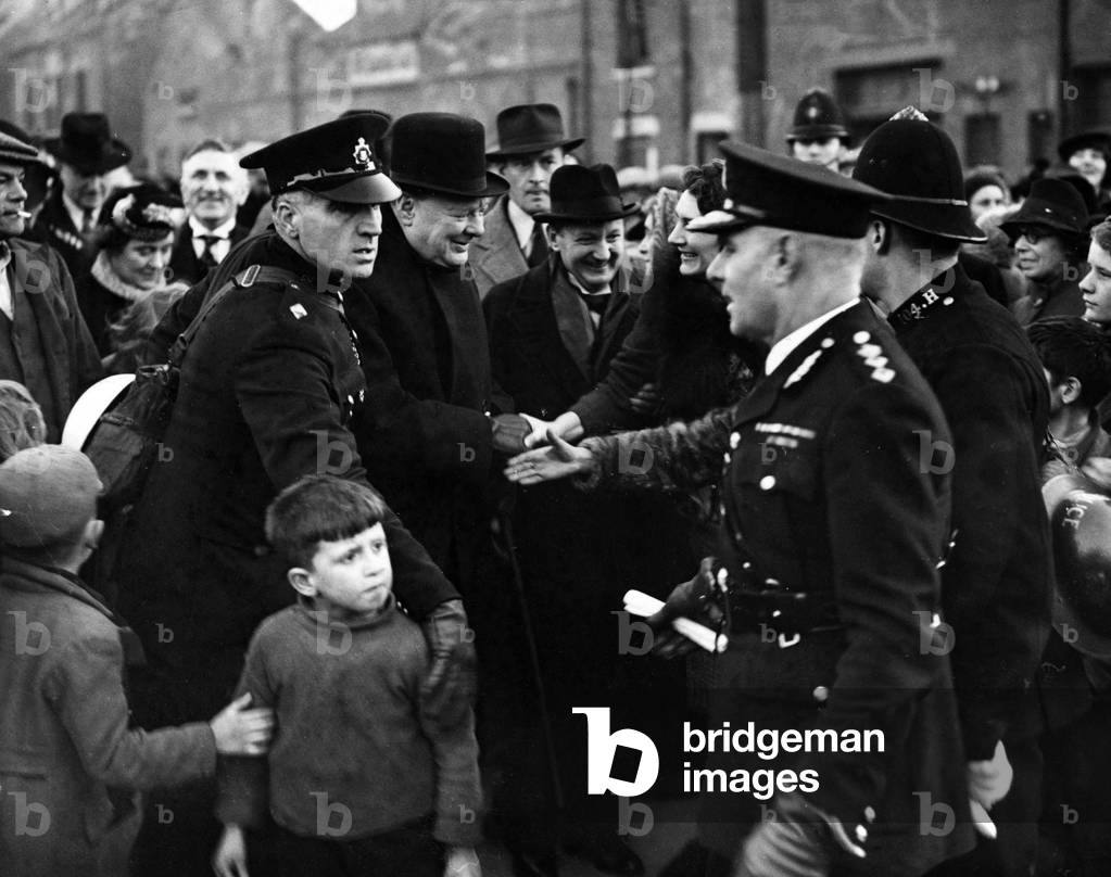 Winston Churchill British Prime Minister shaking hands with people on the street during war time, c. 1940 (b/w photo)