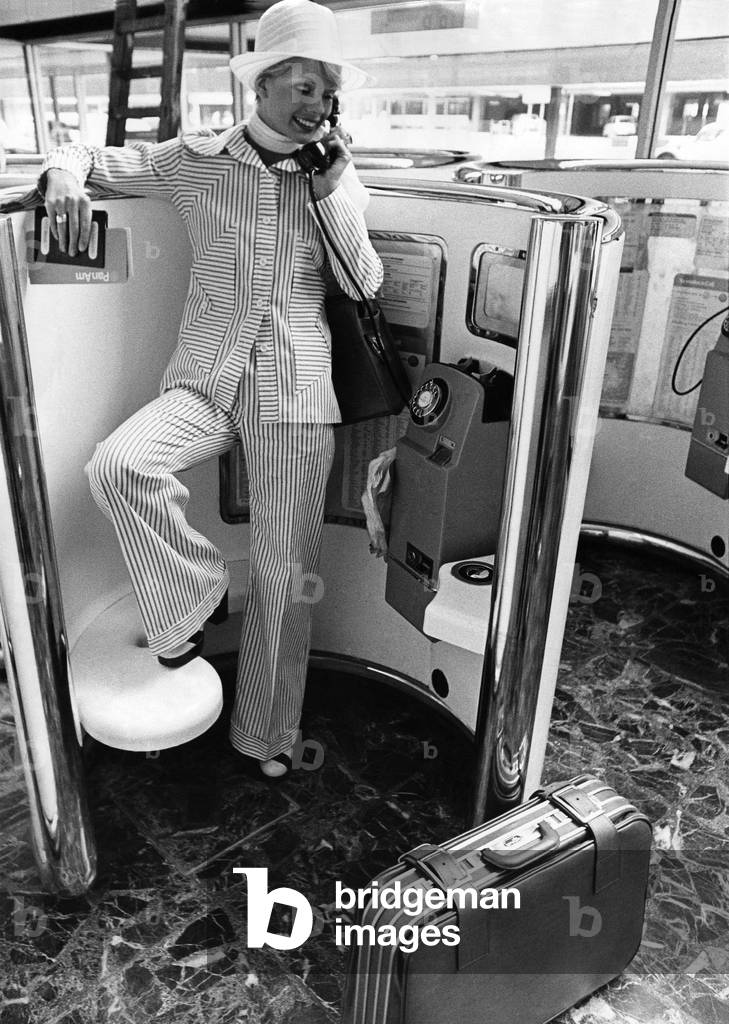 Woman wearing a suit talking on the telephone. 
May 1973