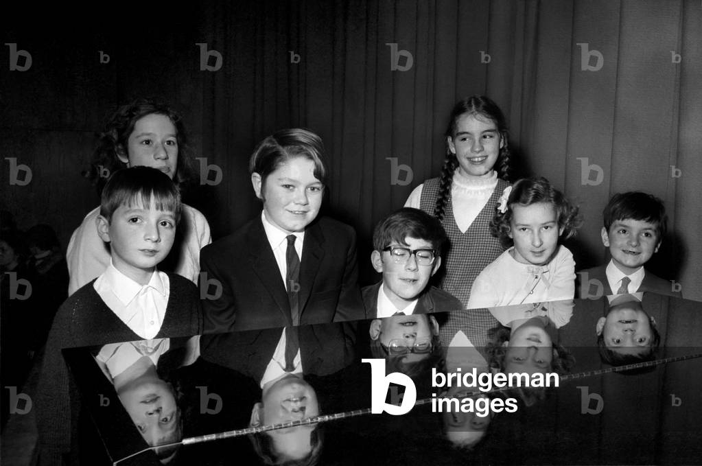 The biggest national event in the world of young pianists for two years, the Final of the National Junior Piano Playing Competition 1969, sponsored by the British piano makers, was held at the Purcell Room of the Royal Festival Hall this morning. 
The contestants in the Junior section are reflected in the top of the grand piano they played during the contest (left to right) winner Francis Rayner (9) from Glamorgan, 3rd, 12 year old Peter Dobson, 2nd Timothy Carey (13) Christine Gott (10) Stephen Hough (7) (back row) Valerie Ashworth (13) Lucy Peacock (13) Valeria Ashworth (13). 
December 1969